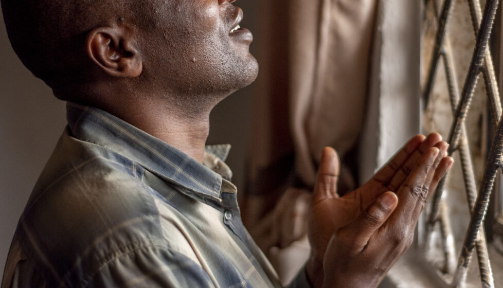 Nigerian Man Praying at a window